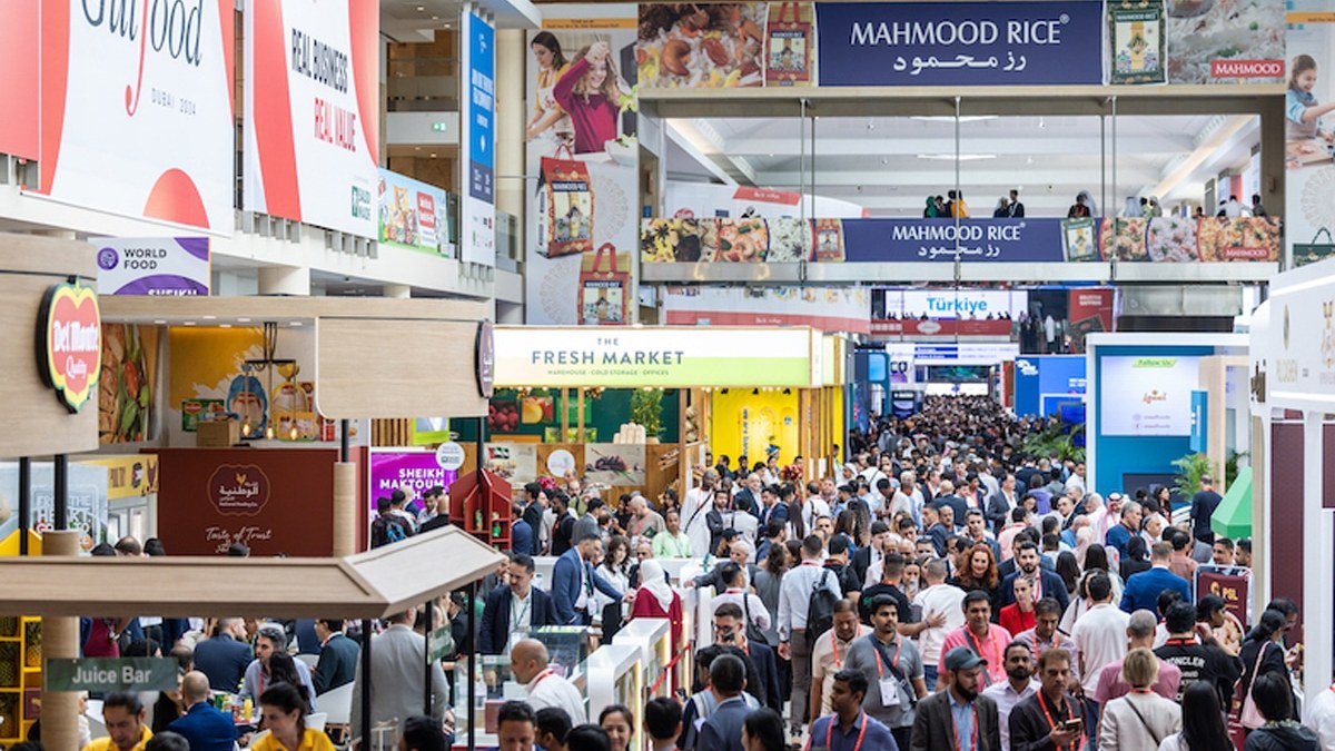 A packed concourse at Gulfood in Dubai, with exhibitor stands and banners on both sides