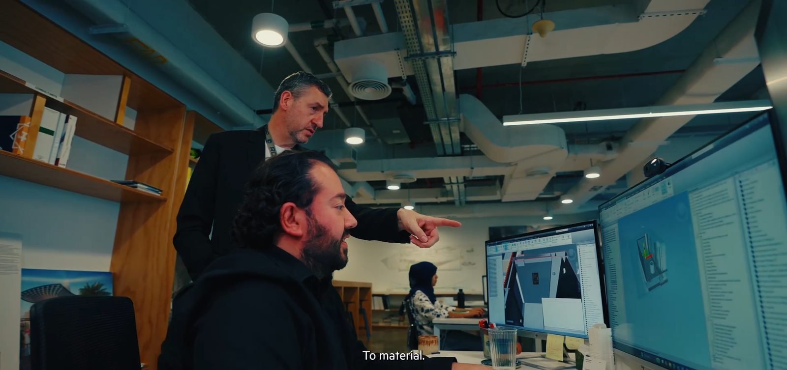 زميلان يراجعان مشروعًا على شاشات كبيرة، لقطة من فيلمنا لـ LWK + Partners