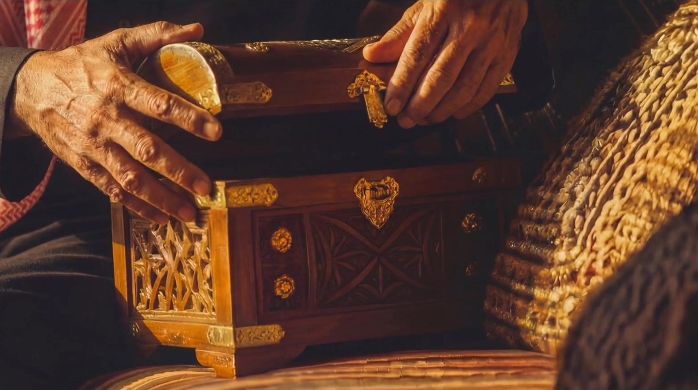 A frame from one of our AI ad films: hands opening an ornate carved wooden chest