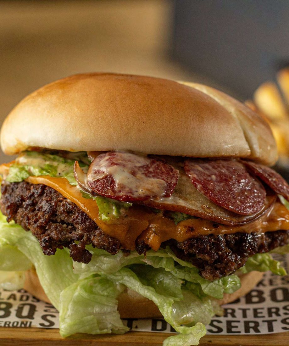 A cheeseburger with salami and lettuce