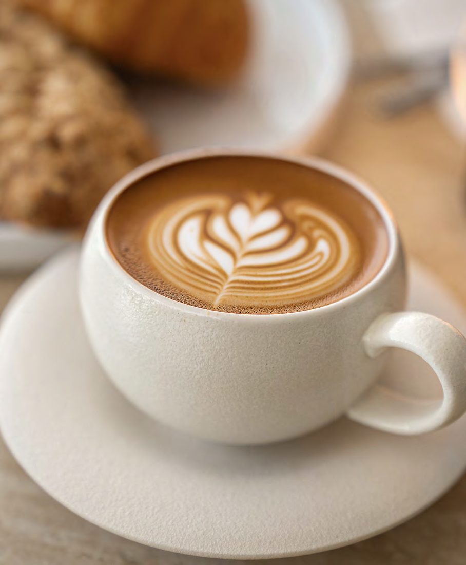 A cappuccino with latte art on a saucer