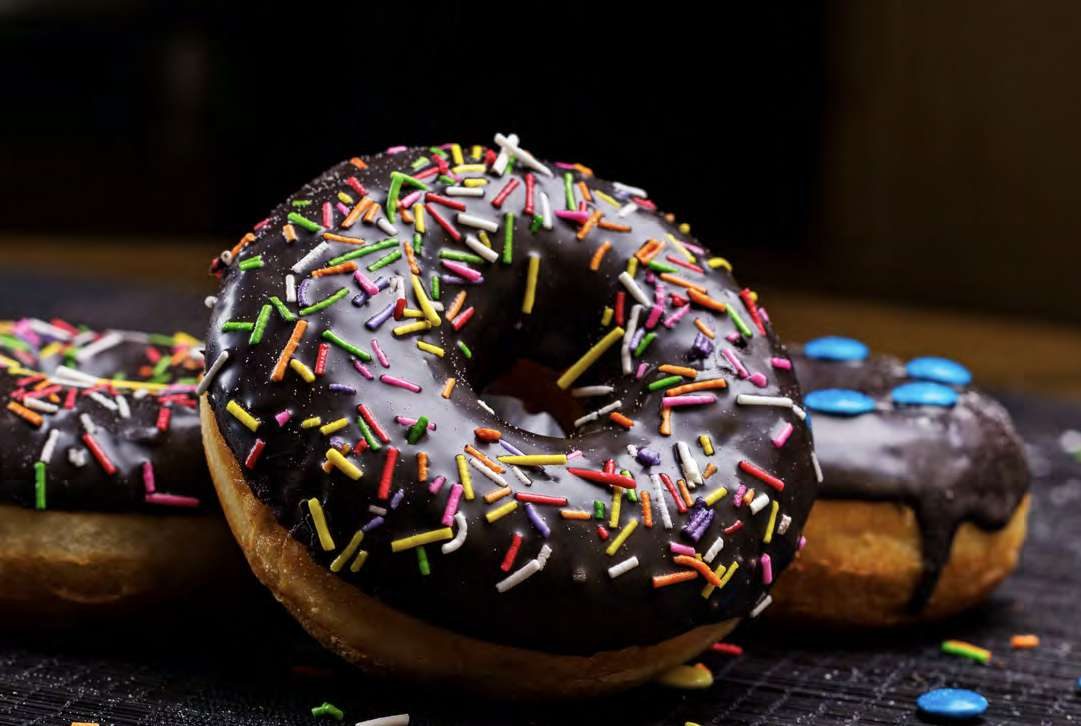 A chocolate donut with sprinkles